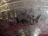 a silver vase with a picture of a man riding a horse
