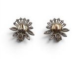 a pair of silver earrings with pearls and diamonds on a white background