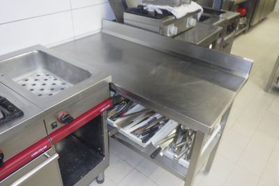 plan de travail en acier inoxydable dans une cuisine professionnelle équipée de tiroirs ouverts