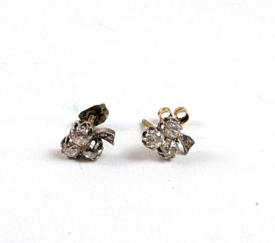 une paire de boucles d'oreilles en diamant sur une surface blanche