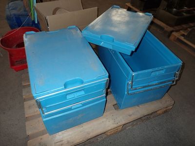 trois caisses bleues posées sur une palette en bois