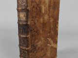 an old book sitting on top of a table next to a white wall