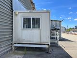 a small white building with a window on the side of it