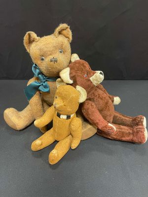 three teddy bears sitting next to each other on a table