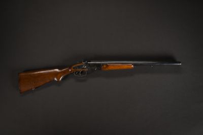 a rifle with a wooden barrel on a black background