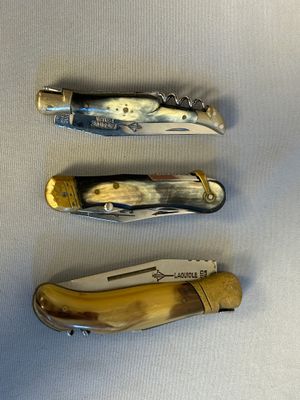 four different types of knives are lined up on a white surface