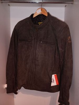 une veste en cuir marron accrochée au mur dans un placard