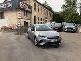 the silver car is parked in front of a building in a parking lot
