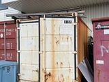de nombreux conteneurs qui sont entreposés à l'extérieur d'un bâtiment
