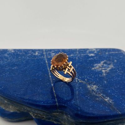a close up of a ring on a blue stone with a gold band