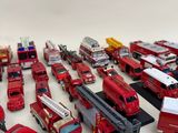 a lot of toy firetrucks and trucks on the table
