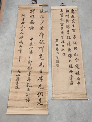 deux calligraphies chinoises posées sur une table, à côté d'une paire de ciseaux