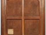 an old wooden frame with a window and a plaque on it