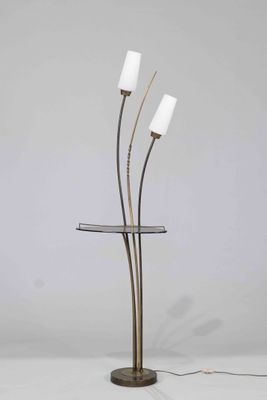 un lampadaire à trois lumières, avec un abat-jour en verre et un pied en métal