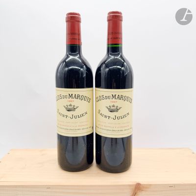 deux bouteilles de vin rouge posées sur une caisse en bois
