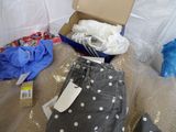 a box of clothes and a pair of jeans on a bed