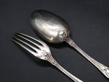 two spoons and a fork on a black surface