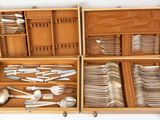 a wooden box filled with silverware and silver spoons