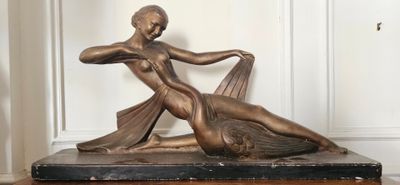 une statue en bronze représentant une femme allongée sur une table