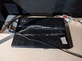 a broken laptop computer sitting on a desk with wires