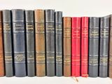 plusieurs vieux livres sont alignés sur une surface blanche