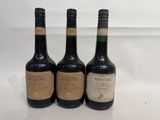 three bottles of wine sitting on top of a white table