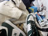 a pile of clothes and a pair of shoes on a bed