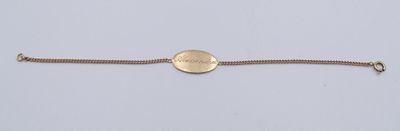 a close up of a gold bracelet with a coin on it