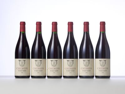 six bottles of red wine lined up in a row