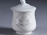 a small white cup with a lid on a table