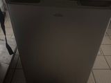 a small refrigerator with a box on top of it