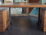 un bureau à deux tiroirs, sur lequel est posé un vase