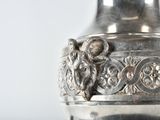a silver vase sitting on a table with a white background