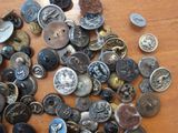 a pile of buttons on a table with some coins