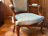 une chaise dont l'assise est recouverte d'un tissu bleu