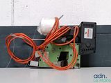 a green and black machine with orange wires attached to it
