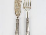 deux fourchettes et un couteau sur une surface blanche
