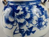 a blue and white tea pot with a bamboo handle