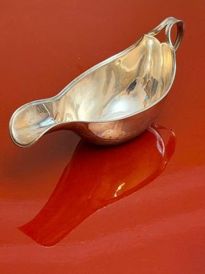 a silver spoon sitting on top of a red car