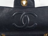 a black chanel bag with gold hardware and chain handles