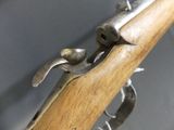 a close up of a wooden rifle with a metal handle