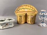 three vases and a candle holder sitting on a table