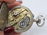 a close up of a person holding a pocket watch