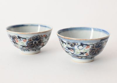 pair of blue and white bowls with floral designs on them on a white surface