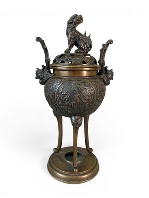 an old bronze incense pot with a bird on top