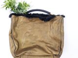 leather handbag with fur trim and black handles on a white background