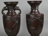 two brown vases sitting next to each other on a gray surface