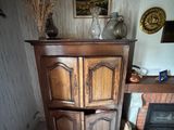 une armoire placée dans un coin d'une pièce dotée d'une cheminée
