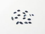 some blue sapphires on a white surface with a white background