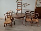 several chairs and a table in a room with a clock on the wall